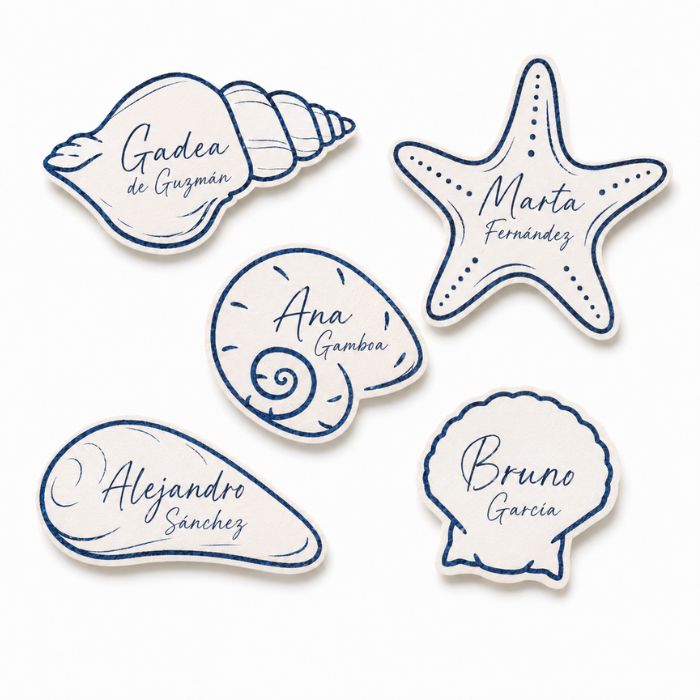 Marcasitios personalizados para boda de la colección Mar con formas marinas troqueladas y nombres de invitados
